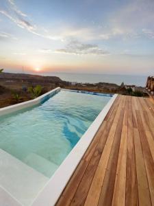 La BocanaにあるUn encuentro mágico con la naturalezaの木製デッキと夕日を望むスイミングプール