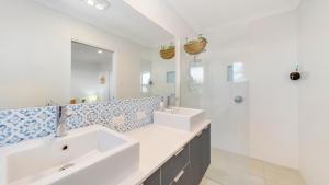 a bathroom with two sinks and a large mirror at Riviera - Pool & quick walk to centre in Bangalow +23 photos
