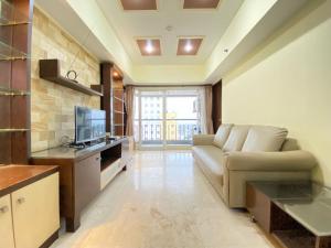 a living room with a couch and a television at Spacious and Modern 2BR at Braga City Walk Apartment By Travelio in Bandung