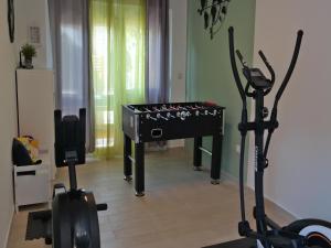 a gym with exercise bikes and a ping pong table at Holiday home in center of ilo near beach in Šilo