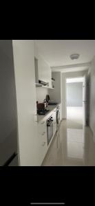 a white kitchen with a stove and a microwave at Umhlanga Modern Nest Studio in Durban