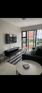 a living room with a couch and a table at Umhlanga Modern Nest Studio in Durban