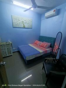 a bedroom with a bed and a couch in a room at Sarah homestay in Port Dickson