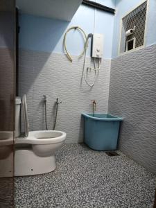 a bathroom with a toilet and a tub in it at Sarah homestay in Port Dickson
