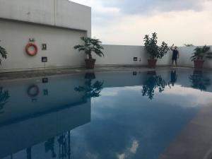 a man standing next to a pool of water at Spacious and Modern 2BR at Braga City Walk Apartment By Travelio in Bandung