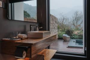 a bathroom with a sink and a large window at 峨眉山和院一溪清音酒店 in Emeishan City