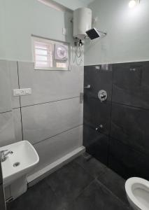 a bathroom with a sink and a toilet at The Karlyle Homestay in Vaduvanchal +9 photos