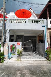 a house with a red umbrella on top of it at Villa Zuzu Holiday Phuket in Kata Beach