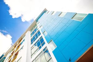 パトンビーチにあるMeet Holiday International Hotel-Patong 普吉岛相遇国际度假酒店-芭东店の青空を背景にしたガラス張りの建物