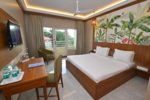 MāvalliRNS Residency Sea View的一间带床和书桌的酒店房间