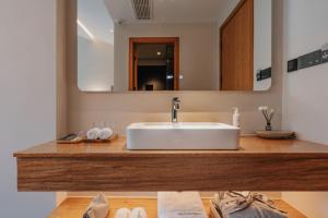 a bathroom with a white sink and a mirror at 峨眉山和院一溪清音酒店 in Emeishan City