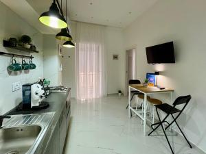 a kitchen with a sink and a table with chairs at Maison Santa Lucia in Naples