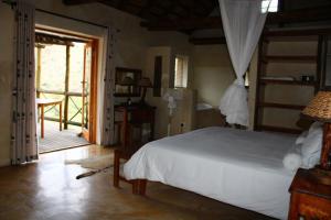 a bedroom with a bed and a door to a patio at Bosch Luys Kloof Nature Reserve in Ladismith +63 photos