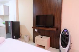 SumedangにあるGreat Deal Studio at Pinewood Apartment By Travelioのベッドルーム(ベッド1台、テレビ、ファン付)