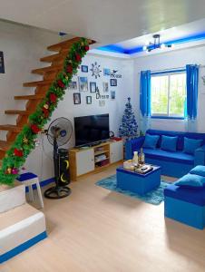 salon z niebieską kanapą i schodami w obiekcie Spacious Home with Beautiful View in Toril Proper w mieście Davao