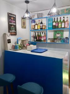 niebieski blat z dwoma krzesłami i butelkami alkoholu w obiekcie Spacious Home with Beautiful View in Toril Proper w mieście Davao +6 zdjęć