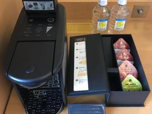 a black printer with a box and two bottles of water at Hotel Monterey Grasmere Osaka in Osaka