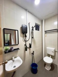 RR Homestay Yong Peng في Yong Peng: حمام مع حوض ومرحاض ومرآة