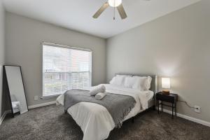 ein Schlafzimmer mit einem großen Bett und einem Deckenventilator in der Unterkunft Chic 1BD Retreat With Pool & Gym, Heart of Medical City Plano in Plano