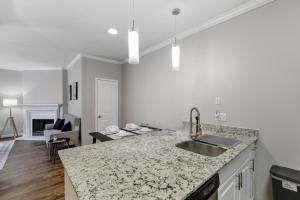 eine Küche mit Spüle und ein Wohnzimmer in der Unterkunft Chic 1BD Retreat With Pool & Gym, Heart of Medical City Plano in Plano + 14 Fotos