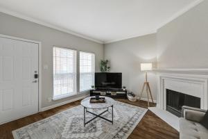 ein Wohnzimmer mit Kamin und Fernseher in der Unterkunft Chic 1BD Retreat With Pool & Gym, Heart of Medical City Plano in Plano