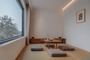 a dining room with a table and a large window at 峨眉山和院一溪清音酒店 in Emeishan City