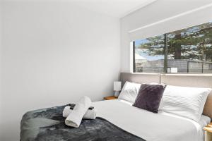 Un dormitorio con una cama con dos toallas encima. en Beach Haven San Remo, en San Remo