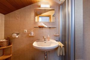 un bagno con lavandino e specchio di Gästehaus Kopp a Stumm