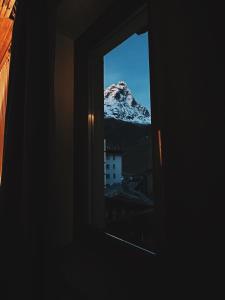 a window with a view of a snow covered mountain at Le Samovar Guest House in Breuil-Cervinia