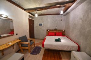 1 dormitorio con cama con almohadas rojas y escritorio en Dhaankolhu Rasdhoo, en Rasdu 34 fotos más