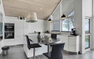 a kitchen with a table and chairs in a room at Awesome Home In Frederikshavn in Frederikshavn