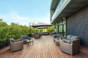 leżak z krzesłami i parasol na budynku w obiekcie Hilton Garden Inn Venice Mestre w Mestre
