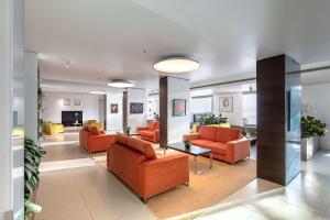 hol z pomarańczowymi krzesłami i stołami w budynku w obiekcie Hilton Garden Inn Venice Mestre w Mestre