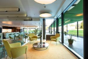 hol z krzesłami, stołem i oknami w obiekcie Hilton Garden Inn Venice Mestre w Mestre