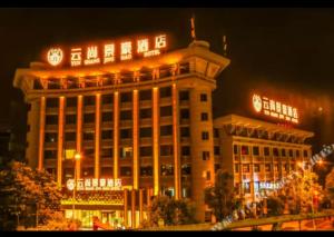 a large building with clocks on top of it at night at 天门山云尚景豪酒店 in Zhangjiajie