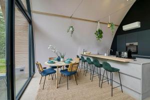 una cucina e una sala da pranzo con tavolo e sedie di Bosresort Maanzicht a Noordwolde