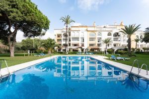 un hotel con piscina frente a un edificio en Mi Patio, Port Of Cabopino, en Marbella