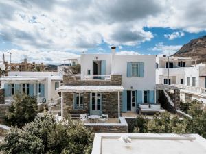 a villa with white walls and blue windows at Samanti House, Leivadi Serifos in Livadi