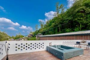 a hot tub on the deck of a house at 峨眉山和院一溪清音酒店 in Emeishan City