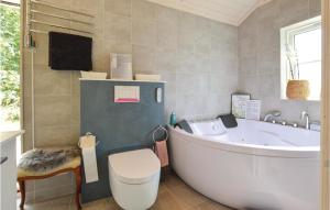 a bathroom with a tub and a toilet and a sink at Four-Bedroom Holiday Home In Hojby in Højby