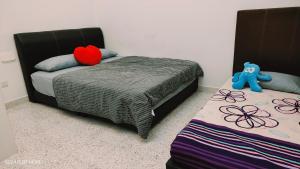 a bedroom with two beds and a blue teddy bear at Sterling Homestay in Tanjung Bungah