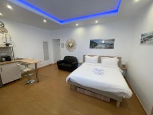 a bedroom with a large white bed and a desk at Residence Akantha in Nice