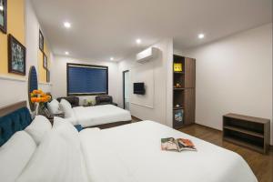 a hotel room with two beds and a tv at Dream Boutique Hotel & Travel & Spa - Hanoi Old Quarter in Hanoi