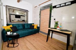 a living room with a green couch and a table at Apartament Kościuszki 2 by LibertaRent in Wałbrzych