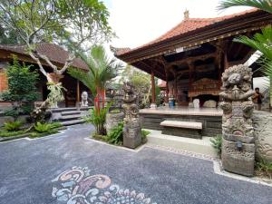 a temple with a bench in front of a building at Wirana Guest House in Ubud