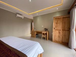 a bedroom with a bed and a wooden cabinet at Wirana Guest House in Ubud +5 photos