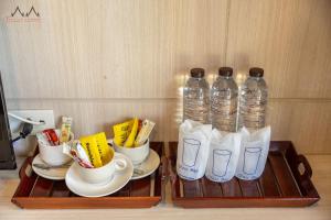 two bottles of water sitting on a tray with cups at Tommy Resort in Haad Rin