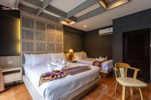 a hotel room with two beds and a chair at Tommy Resort in Haad Rin +37 photos