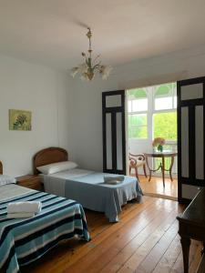 ein Schlafzimmer mit zwei Betten und einem Tisch und Fenstern in der Unterkunft Corias Casona junto al Narcea in Corias