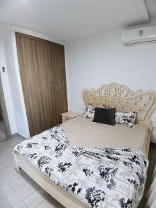 una camera da letto con un letto con un piumone bianco e nero di Super loft B51 a Hammamet